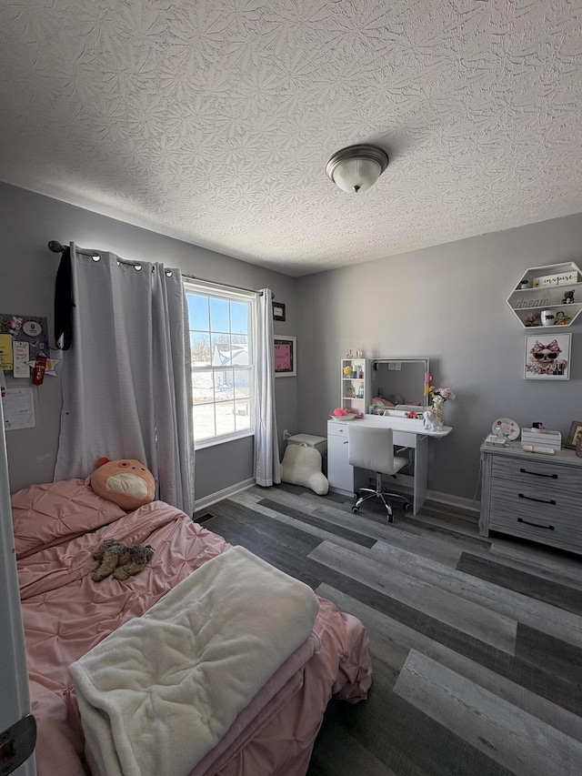 bedroom featuring a textured ceiling and dark wood-type flooring