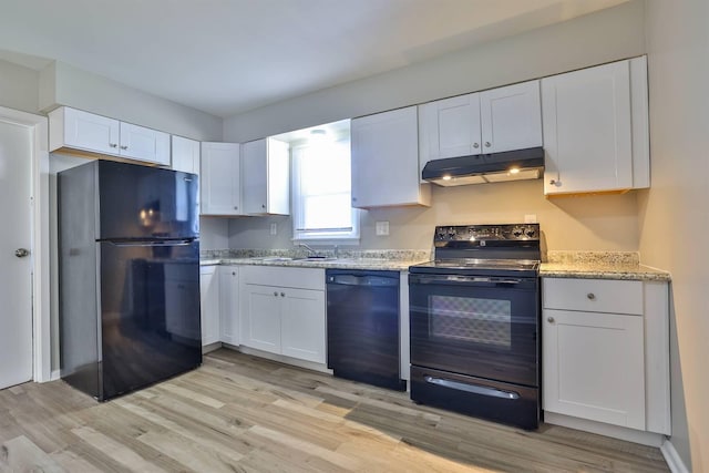 kitchen featuring white cabinetry, light hardwood / wood-style flooring, black appliances, light stone countertops, and sink