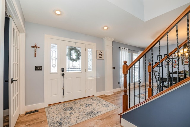 entrance foyer with light hardwood / wood-style floors and ornate columns