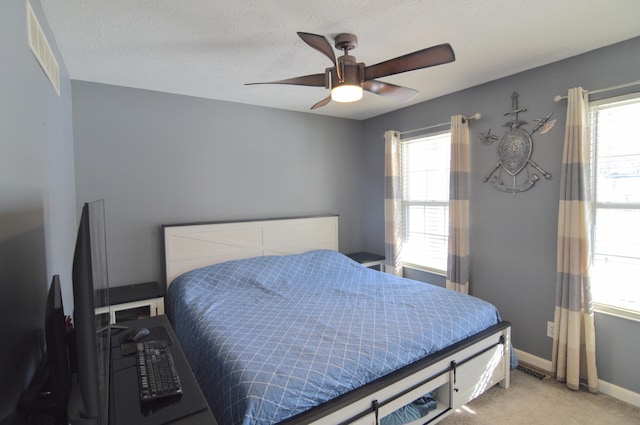 carpeted bedroom featuring a textured ceiling and ceiling fan