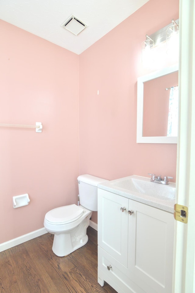 bathroom featuring toilet, wood-type flooring, and vanity