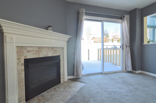 unfurnished living room featuring a tile fireplace and carpet