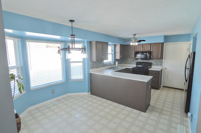 kitchen with sink, decorative light fixtures, ceiling fan, kitchen peninsula, and black appliances