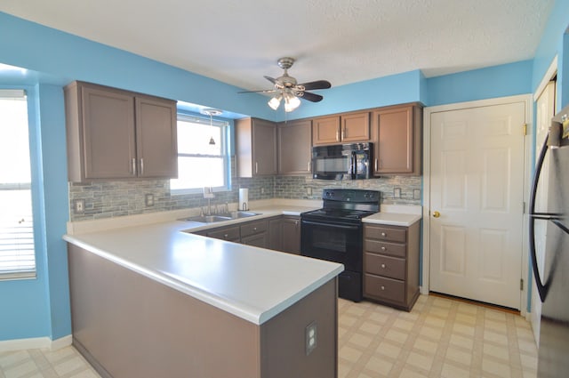 kitchen with black appliances, kitchen peninsula, ceiling fan, decorative backsplash, and sink