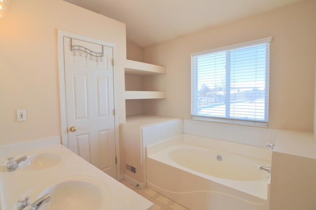 bathroom featuring built in shelves, a bath, and vanity