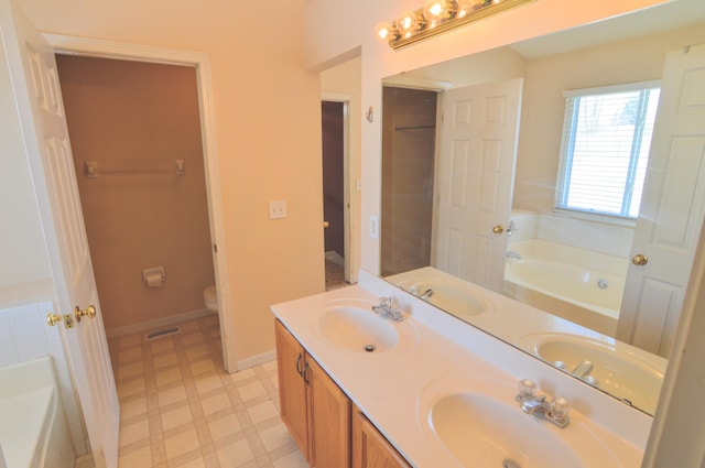 bathroom with toilet, vanity, and a bathing tub