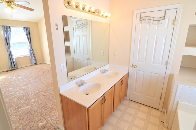 bathroom featuring ceiling fan, a tub, and vanity