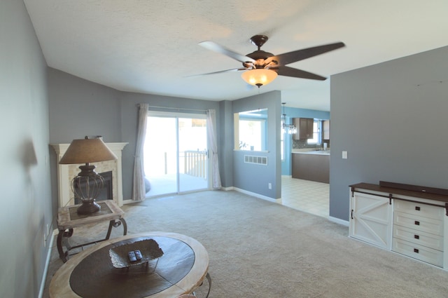 sitting room with a textured ceiling, ceiling fan, and light colored carpet