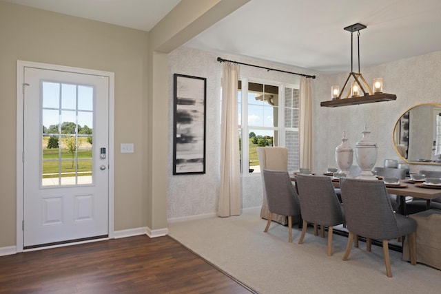 dining area with dark hardwood / wood-style flooring, beamed ceiling, and a chandelier