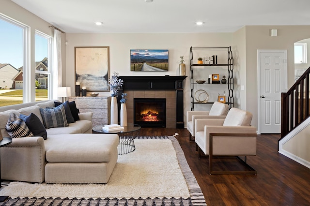 living room with dark hardwood / wood-style floors and a tiled fireplace