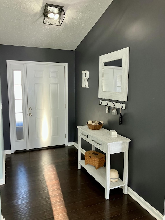 foyer entrance featuring dark wood-type flooring and a textured ceiling