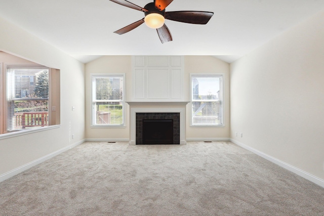 unfurnished living room featuring a fireplace, ceiling fan, vaulted ceiling, and light colored carpet