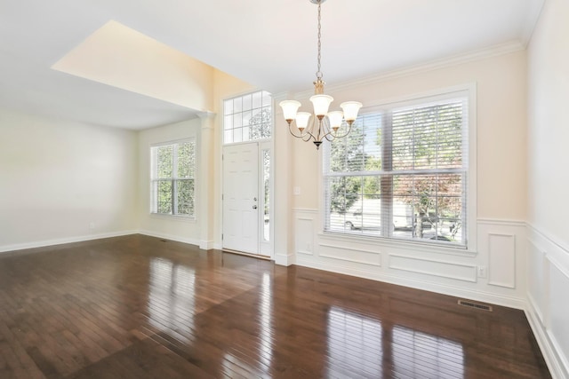 interior space with an inviting chandelier, decorative columns, and dark hardwood / wood-style floors