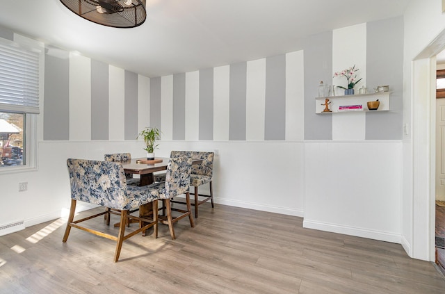 dining area featuring wood-type flooring and a baseboard heating unit