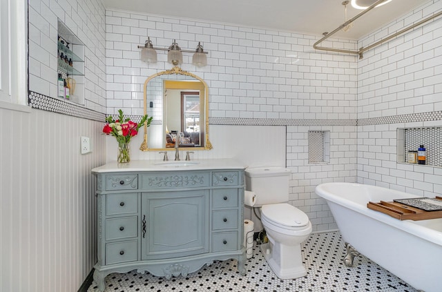 bathroom featuring tile walls, toilet, tile patterned floors, a tub, and vanity