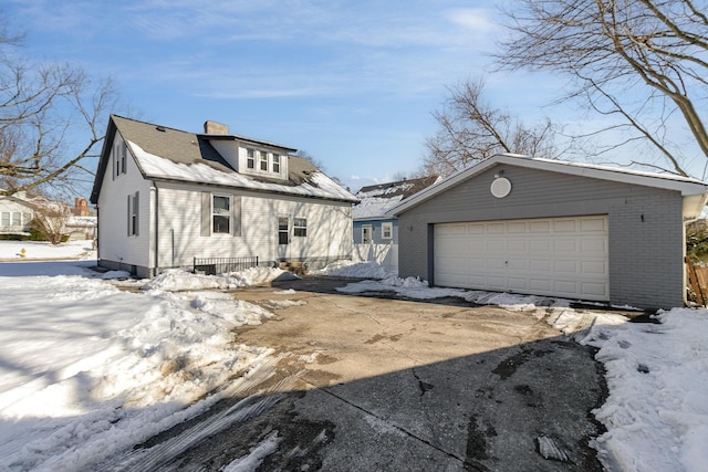 view of front of home with a garage and an outbuilding