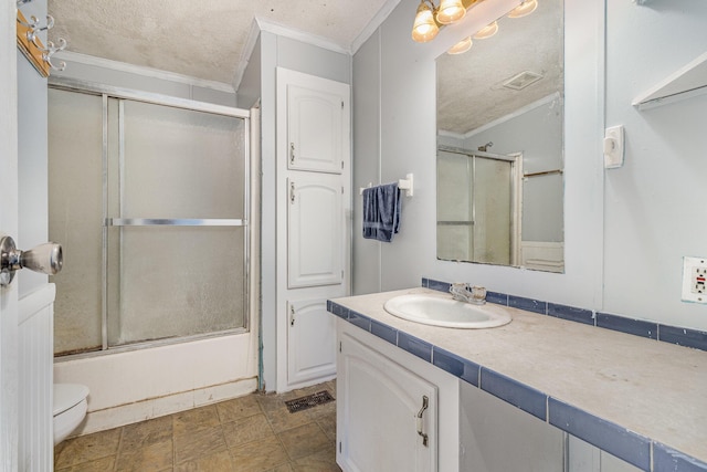 full bath featuring a textured ceiling, toilet, vanity, and ornamental molding