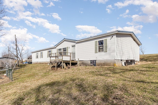 rear view of property featuring crawl space, a lawn, and central AC