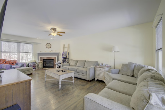 living room with a brick fireplace, ceiling fan, and dark hardwood / wood-style flooring