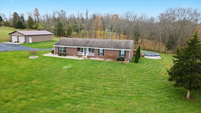 view of front of home featuring a garage, a front yard, and an outdoor structure