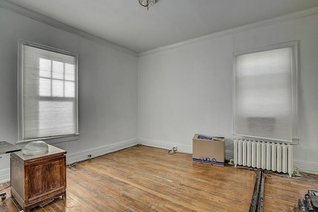 empty room with radiator, ornamental molding, and light wood-type flooring