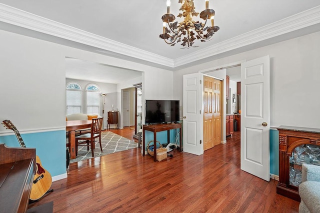 living room featuring ornamental molding, a chandelier, and hardwood / wood-style floors