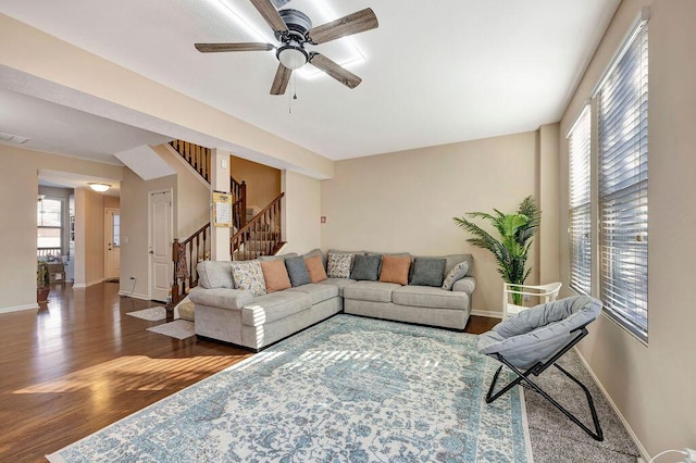 living room with ceiling fan and dark wood-type flooring