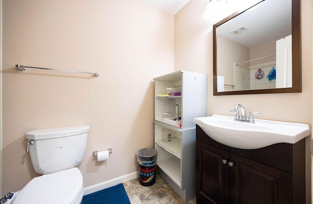 bathroom with toilet, vanity, and walk in shower