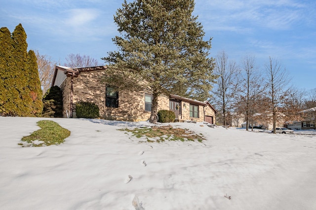 view of snow covered exterior featuring a garage