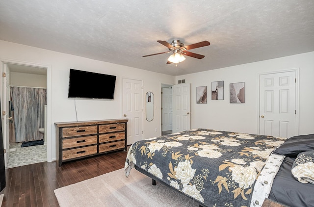 bedroom featuring a textured ceiling, connected bathroom, ceiling fan, and dark hardwood / wood-style floors