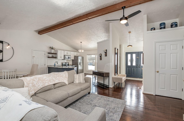 living room with a textured ceiling, lofted ceiling with beams, dark hardwood / wood-style flooring, ceiling fan, and sink