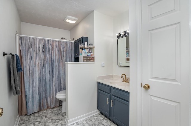 bathroom featuring toilet, walk in shower, and vanity