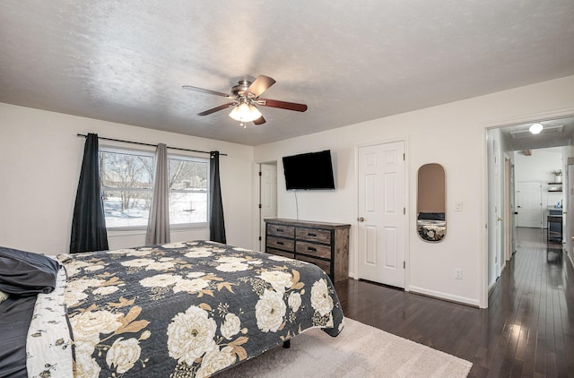 bedroom featuring a textured ceiling, ceiling fan, and dark hardwood / wood-style flooring