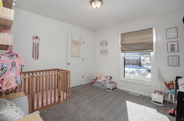 bedroom with a crib and carpet