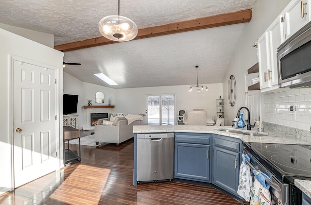 kitchen with sink, blue cabinets, pendant lighting, and appliances with stainless steel finishes