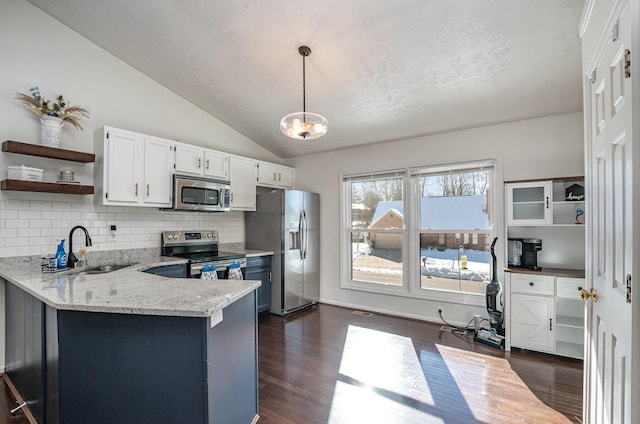 kitchen featuring kitchen peninsula, pendant lighting, stainless steel appliances, white cabinetry, and sink