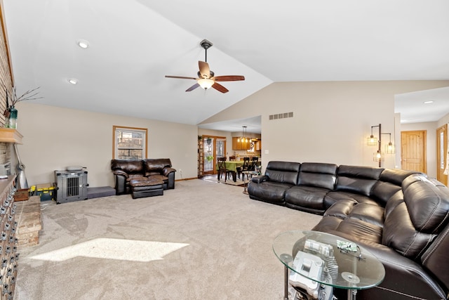 living room featuring vaulted ceiling, ceiling fan with notable chandelier, and carpet floors