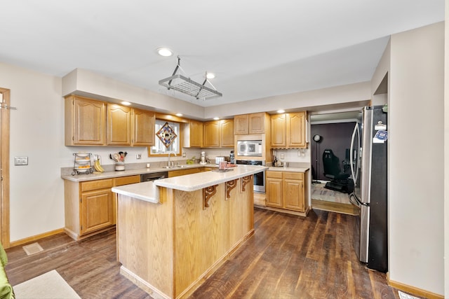 kitchen with a center island, dark wood-type flooring, stainless steel appliances, sink, and a breakfast bar area