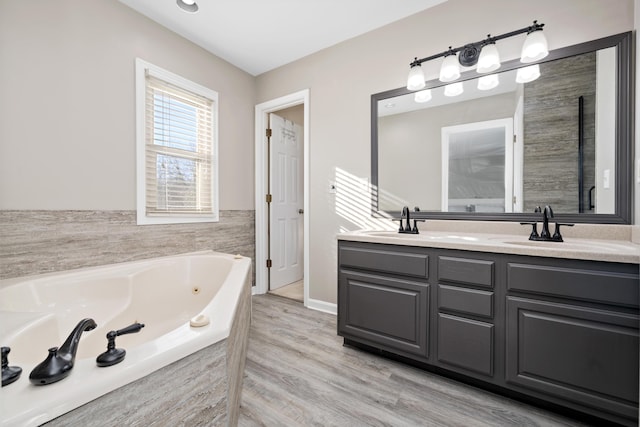 bathroom featuring vanity, a relaxing tiled tub, and hardwood / wood-style flooring