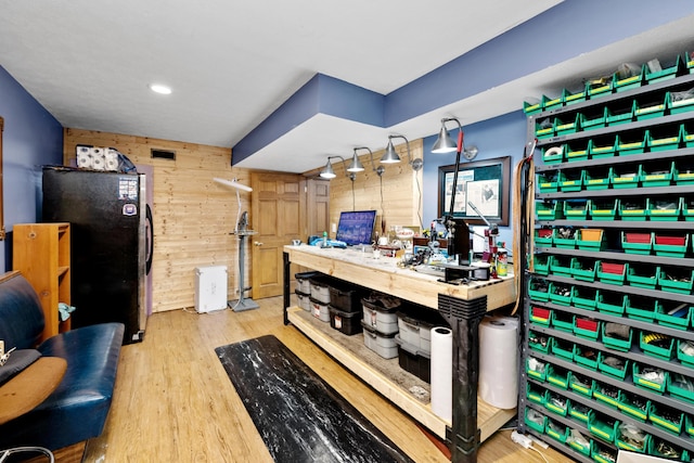 bar with hardwood / wood-style flooring, butcher block countertops, stainless steel fridge, and wooden walls