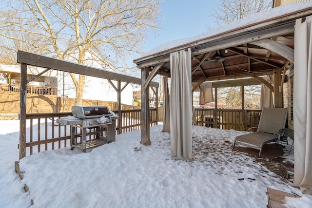 snow covered deck with ceiling fan and area for grilling