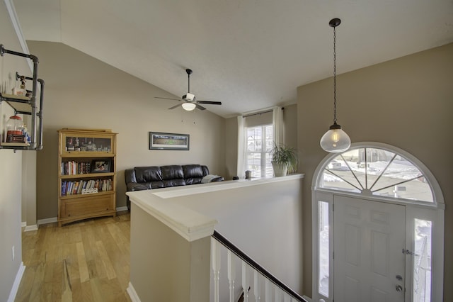 foyer entrance with vaulted ceiling, ceiling fan, and light wood-type flooring