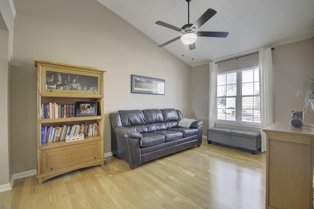 sitting room featuring lofted ceiling, light wood-type flooring, a textured ceiling, and ceiling fan