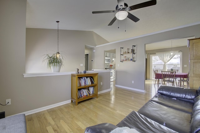 living room featuring ceiling fan, wood-type flooring, and vaulted ceiling