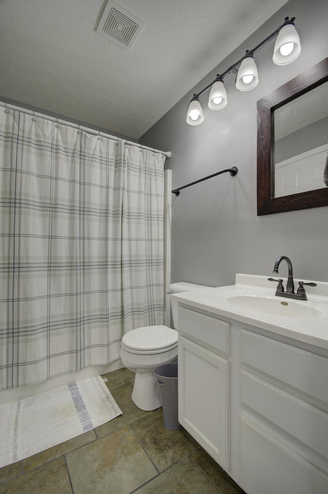 bathroom featuring toilet, a textured ceiling, a shower with curtain, and vanity