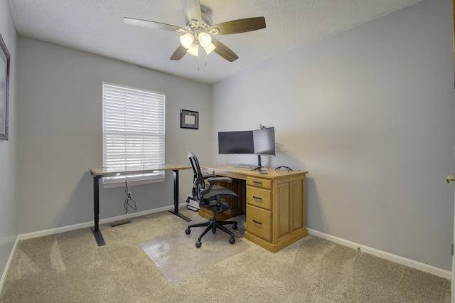 office space with light carpet, ceiling fan, and a textured ceiling