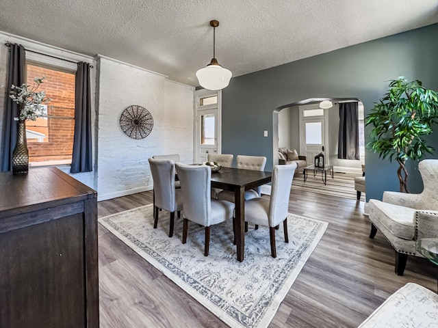 dining room featuring a textured ceiling and wood-type flooring