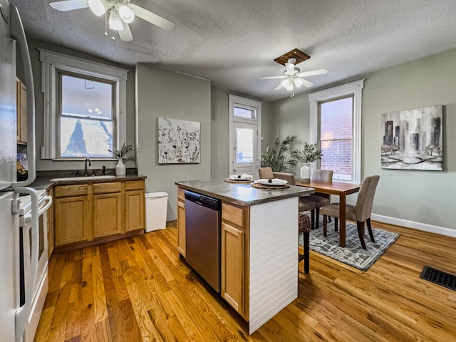 kitchen featuring a textured ceiling, dishwasher, light hardwood / wood-style flooring, ceiling fan, and sink