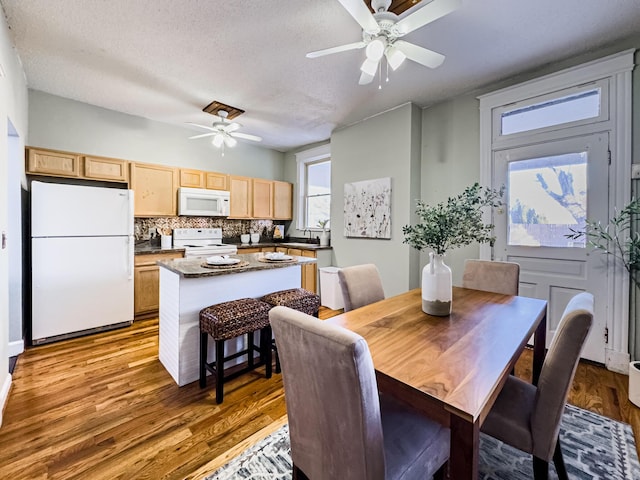 dining room featuring sink, a textured ceiling, ceiling fan, and hardwood / wood-style flooring