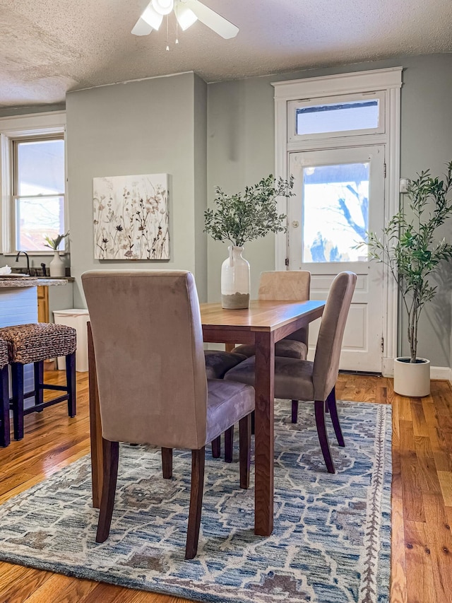 dining space with a textured ceiling, hardwood / wood-style floors, and ceiling fan